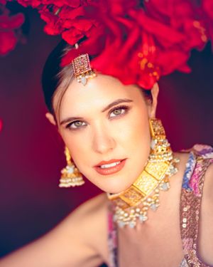 A stunning portrait captures the elegance and grace of an Indian bride on her wedding day. Dressed in a richly embroidered traditional gown,