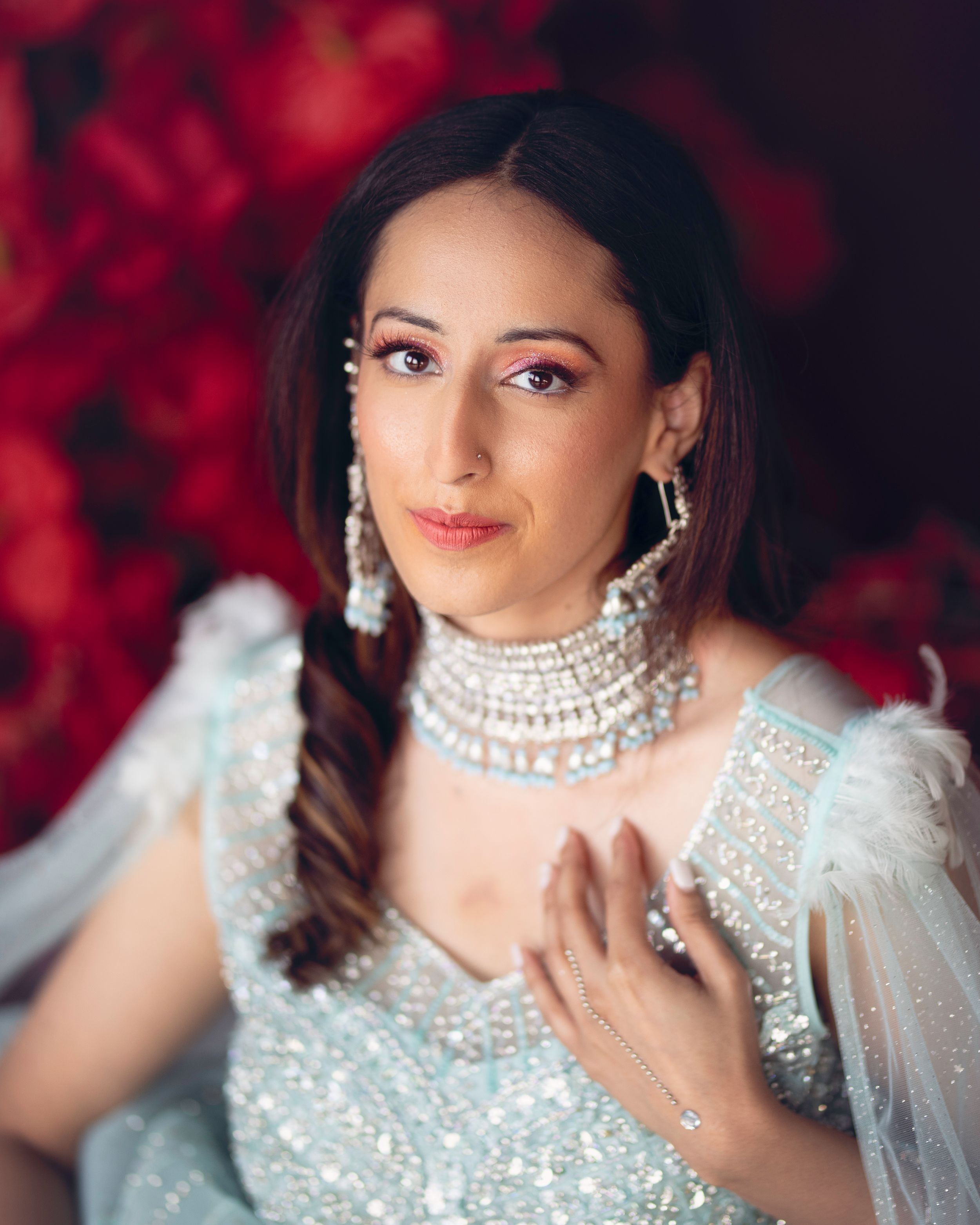 A stunning portrait captures the elegance and grace of an Indian bride on her wedding day. Dressed in a richly embroidered traditional gown,