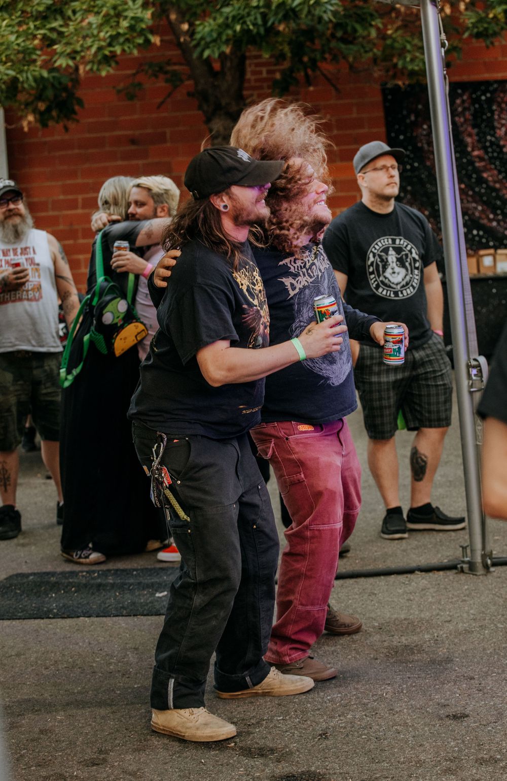 Concert attendees enjoying music at an outdoor event near brick buildings.
