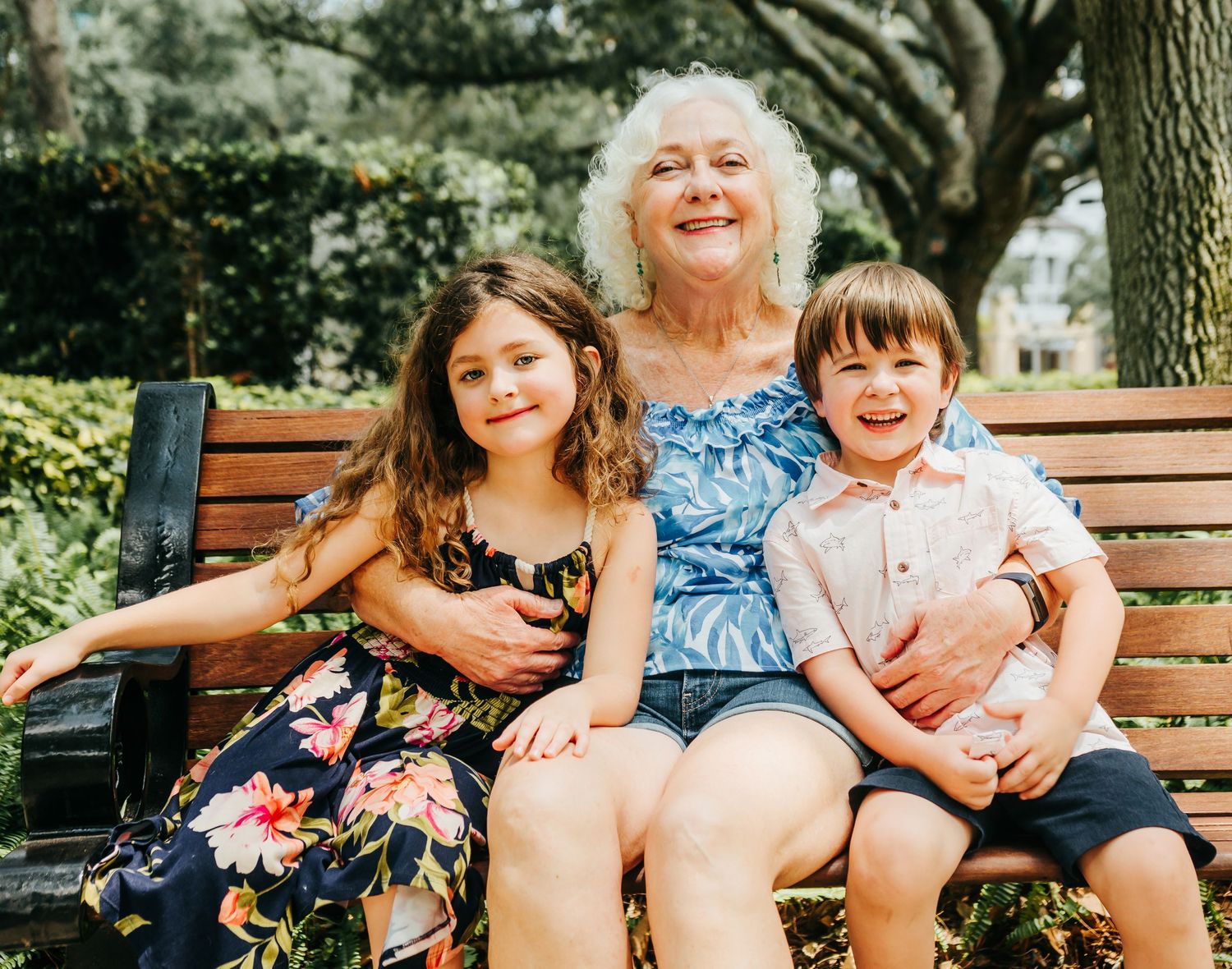 Outdoor Family Session in St. Pete, FL; Grandmother posing with grandkids on park bench
