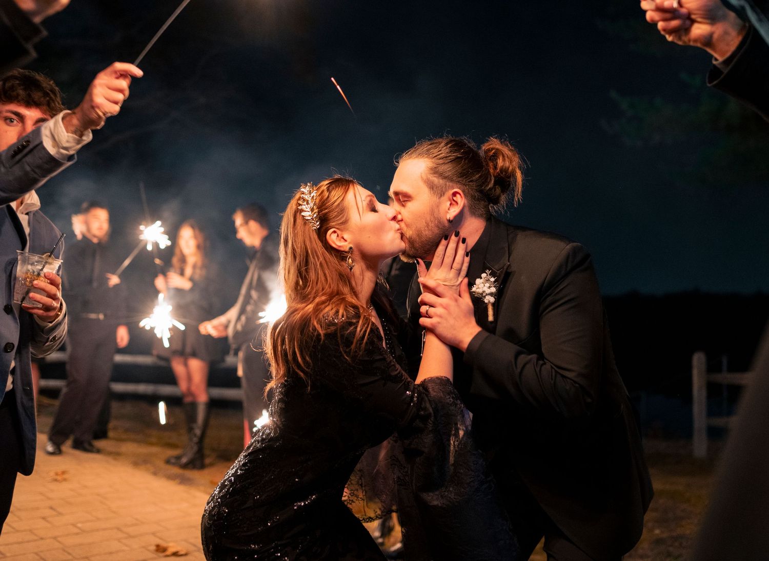 Romantic nighttime celebration with sparklers during outdoor wedding festivities.