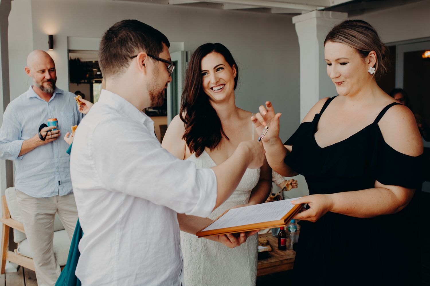 A small group celebrating during what appears to be an indoor wedding ceremony.