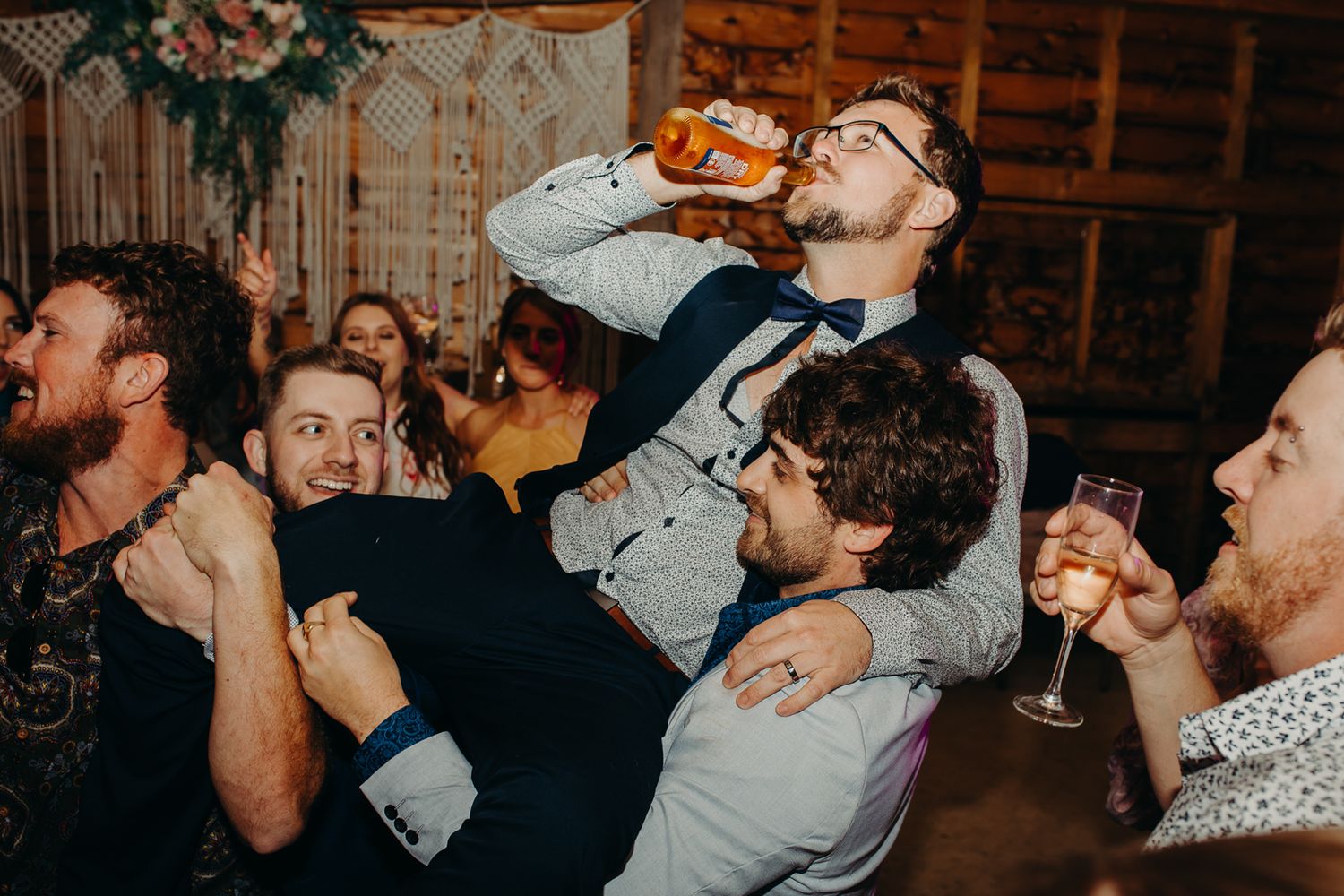 Energetic wedding reception party scene with guests dancing and celebrating.
