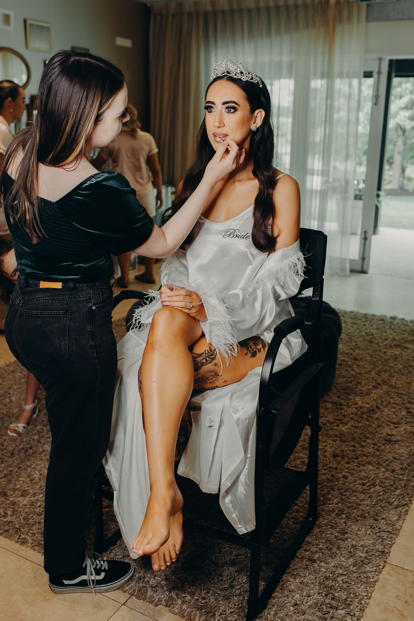 Makeup artist applies finishing touches during bridal preparation.