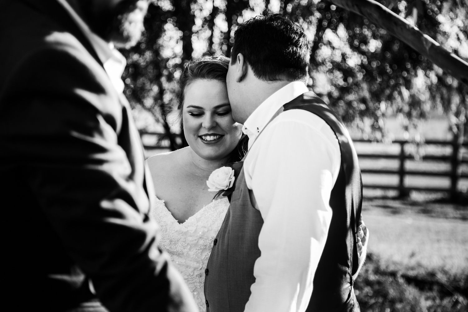 Black and white candid moment between couple during wedding ceremony.