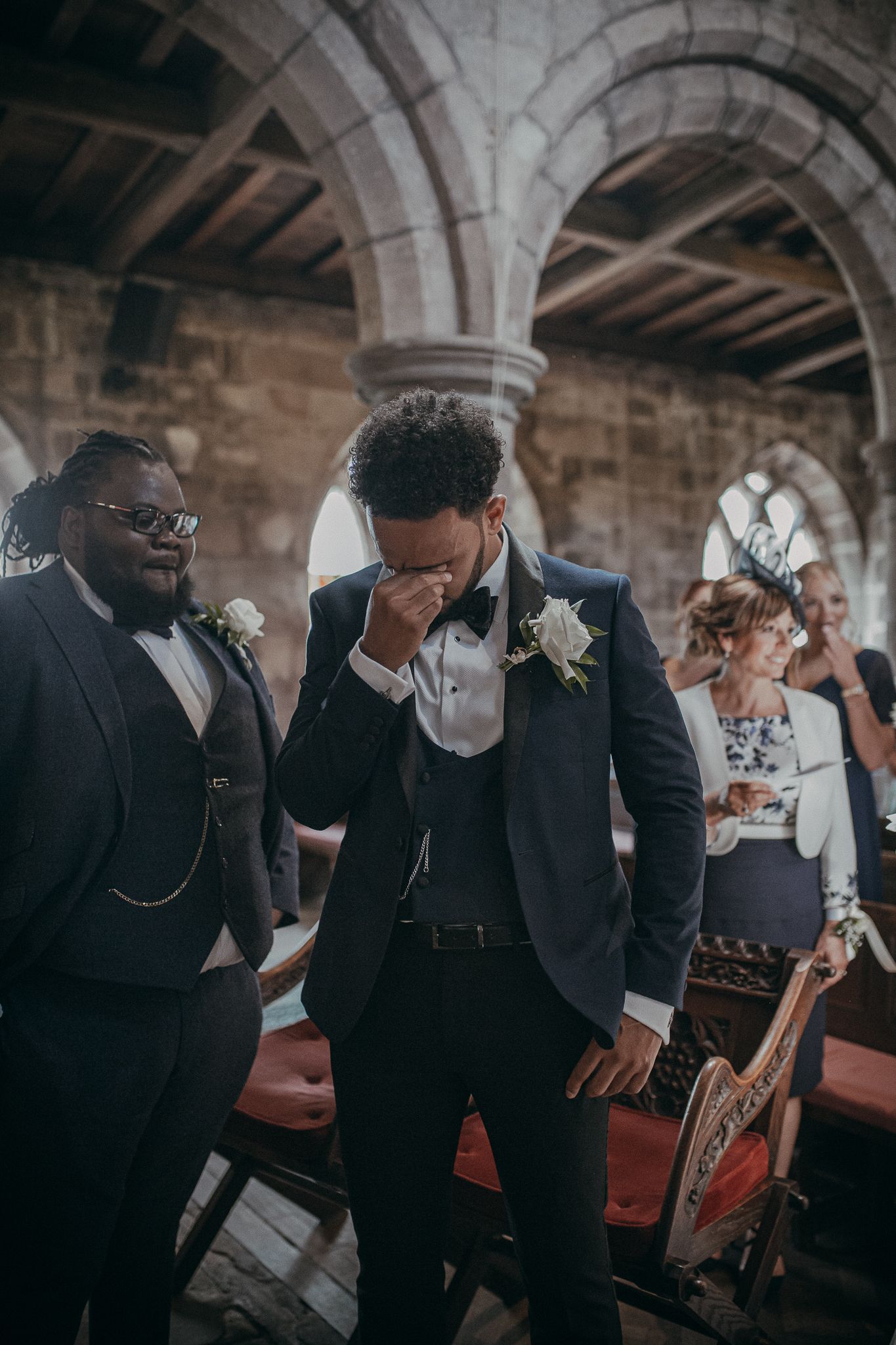 Emotional moment captured in a stone archway during wedding ceremony.