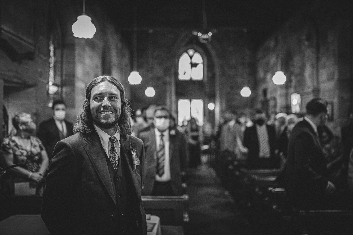 Black and white photo of wedding reception in a dimly lit vintage venue.