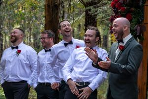 groom, best man and groomsmen laughing.