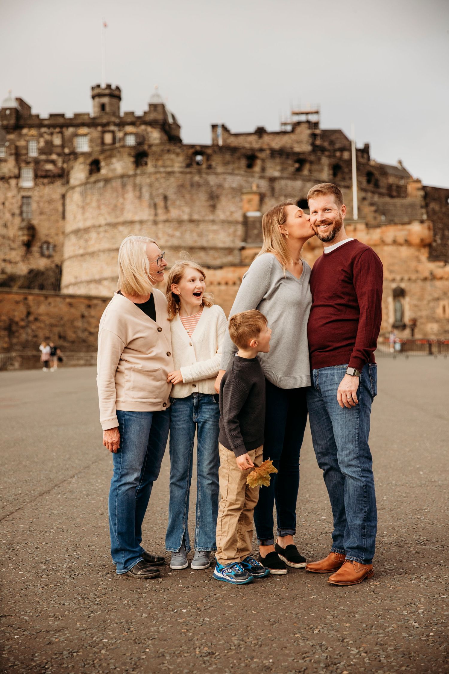 Family poses for a portrait with Edinburgh Castle looming in the background.