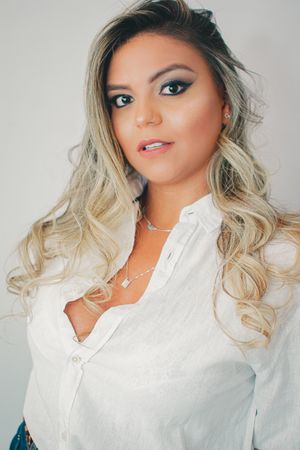 Professional headshots in white button-down shirt against neutral background.