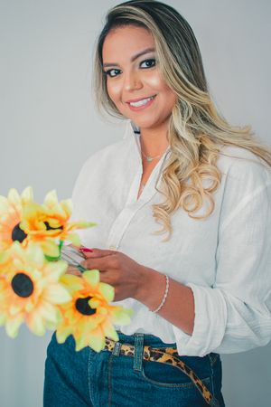 Fashion photo series showing a casual summer outfit with white button-down shirt and denim shorts accessorized with sunflowers.