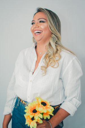 Lifestyle portraits featuring a bright white blouse and casual denim styling with cheerful sunflower accents.