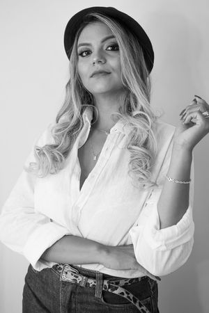 Black and white fashion portraits showing casual style with white button-down shirt and hat accessories.