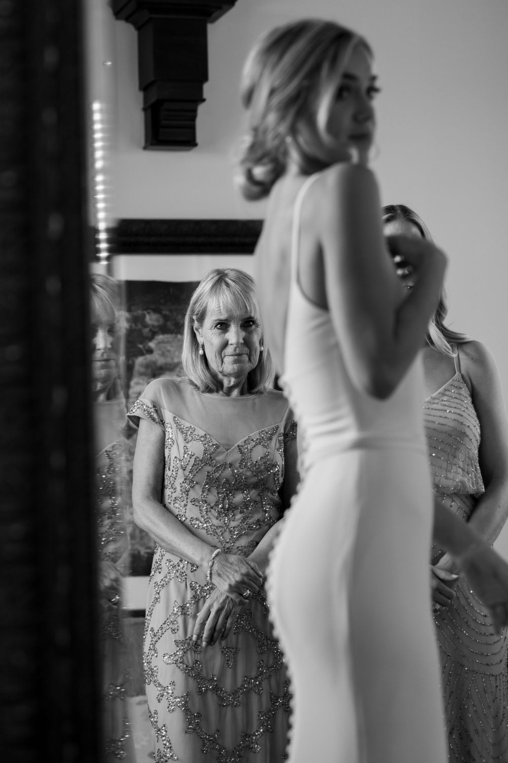 Elegant formal gown moments shared between two people during special occasion preparation.