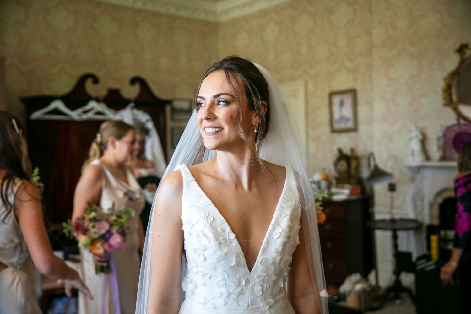Bridal preparation scene in an elegant room with vintage decor and natural lighting.