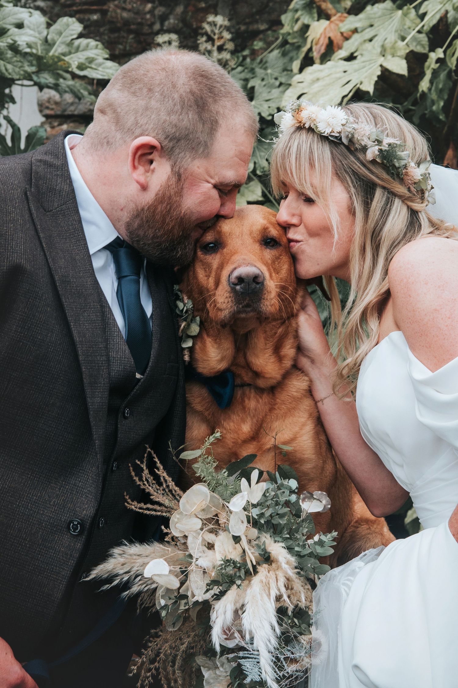 Couple on their wedding kissing their dog in devon based wedding