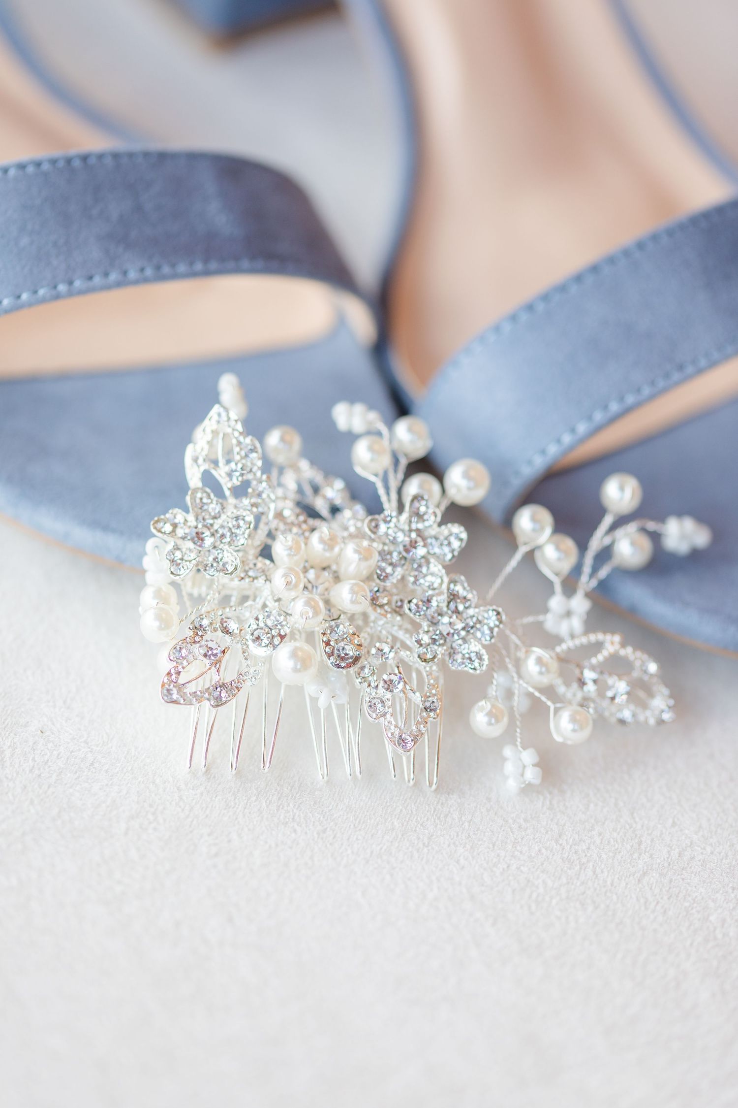Crystal and pearl bridal hair accessory next to powder blue shoes.