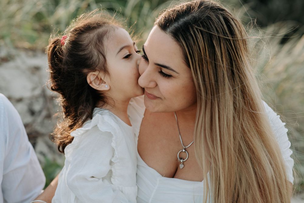An intimate mother-daughter moment captured during an outdoor portrait session.