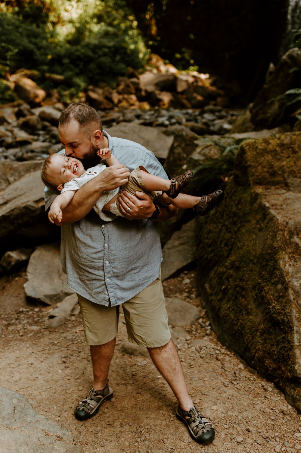 A playful moment between parent and child among rocky forest terrain.