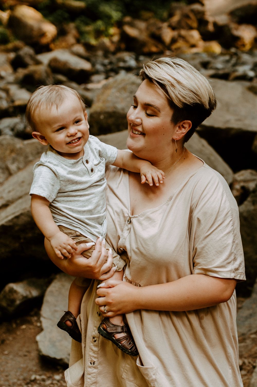 A sweet moment between parent and child captured against a rocky natural backdrop.