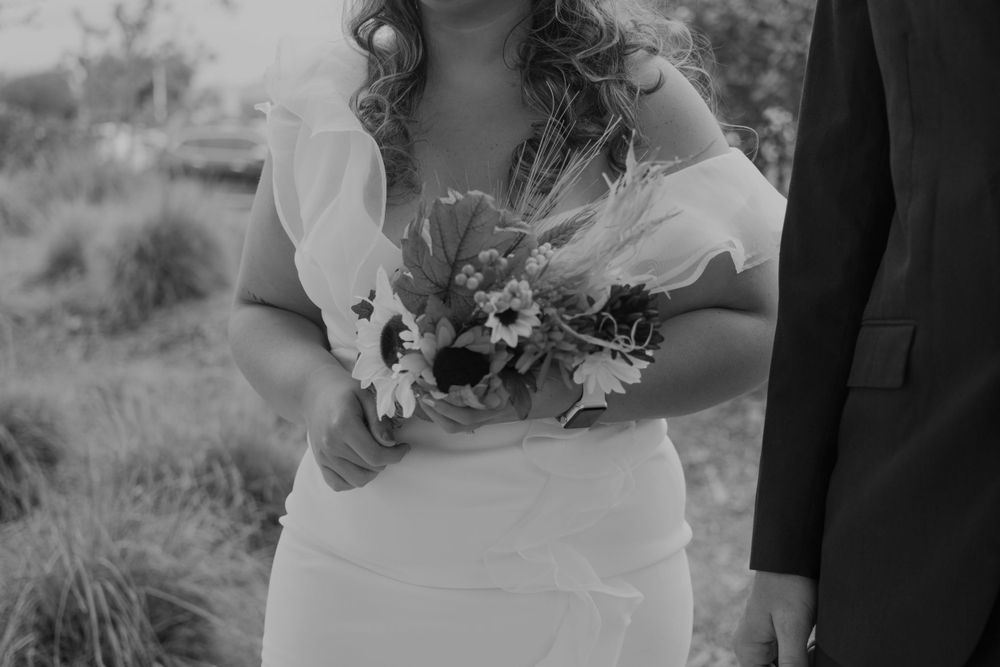 Black and white close-up of wedding bouquet being held.