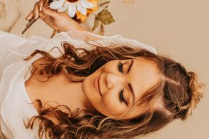 Ethereal portrait featuring dried flowers and soft natural lighting in a dreamy autumn-toned composition.