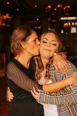 Two friends sharing an intimate moment in a dimly lit restaurant setting with warm lighting.