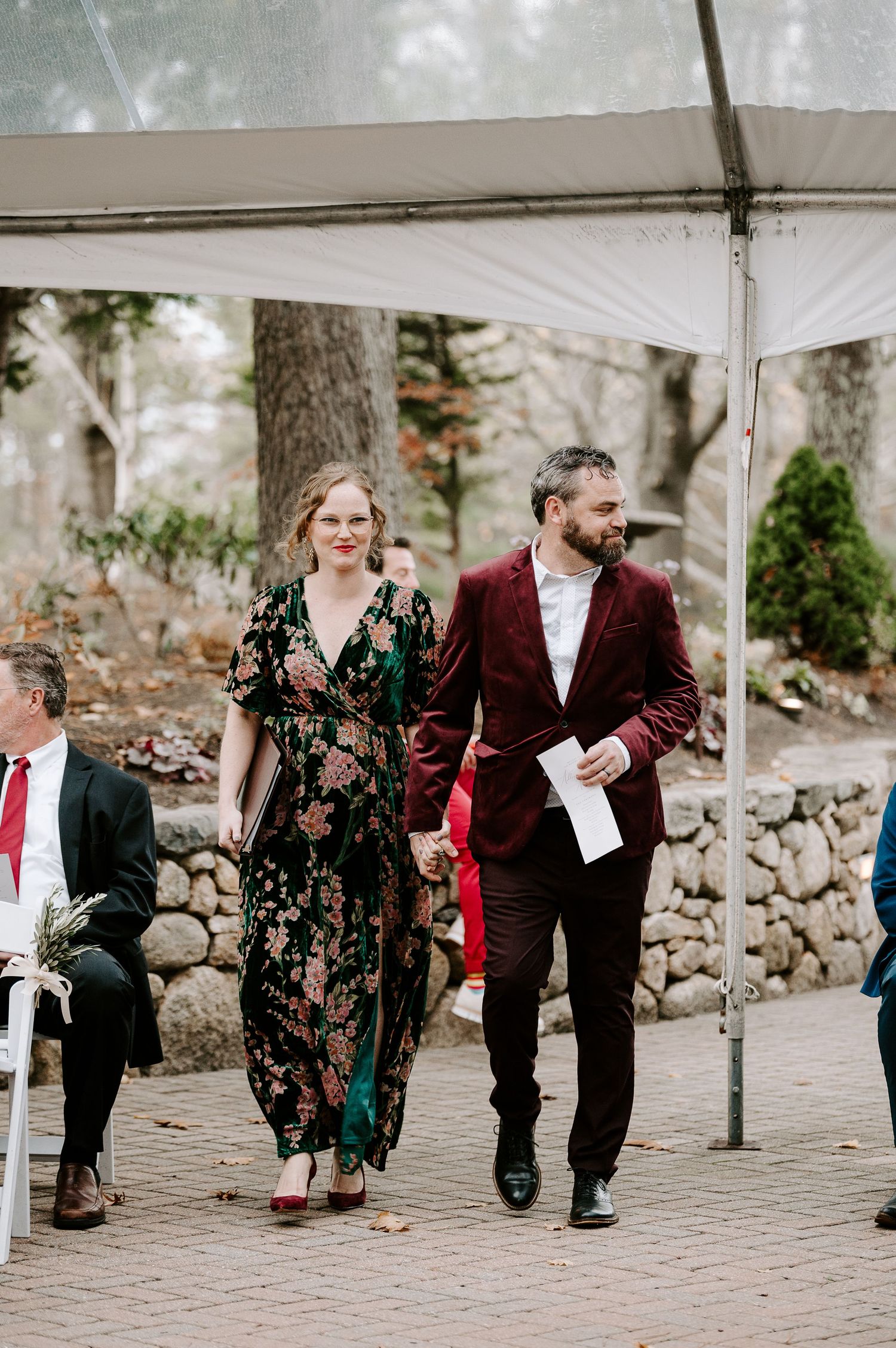 Wedding guests enjoying themselves under a tent at an outdoor reception venue.