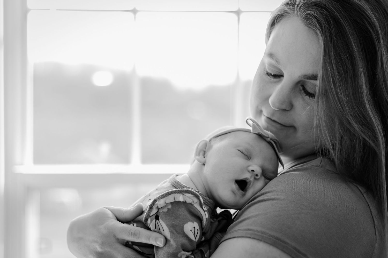 A mother cradles her soundly sleeping baby, this beautiful baby is pure innocence