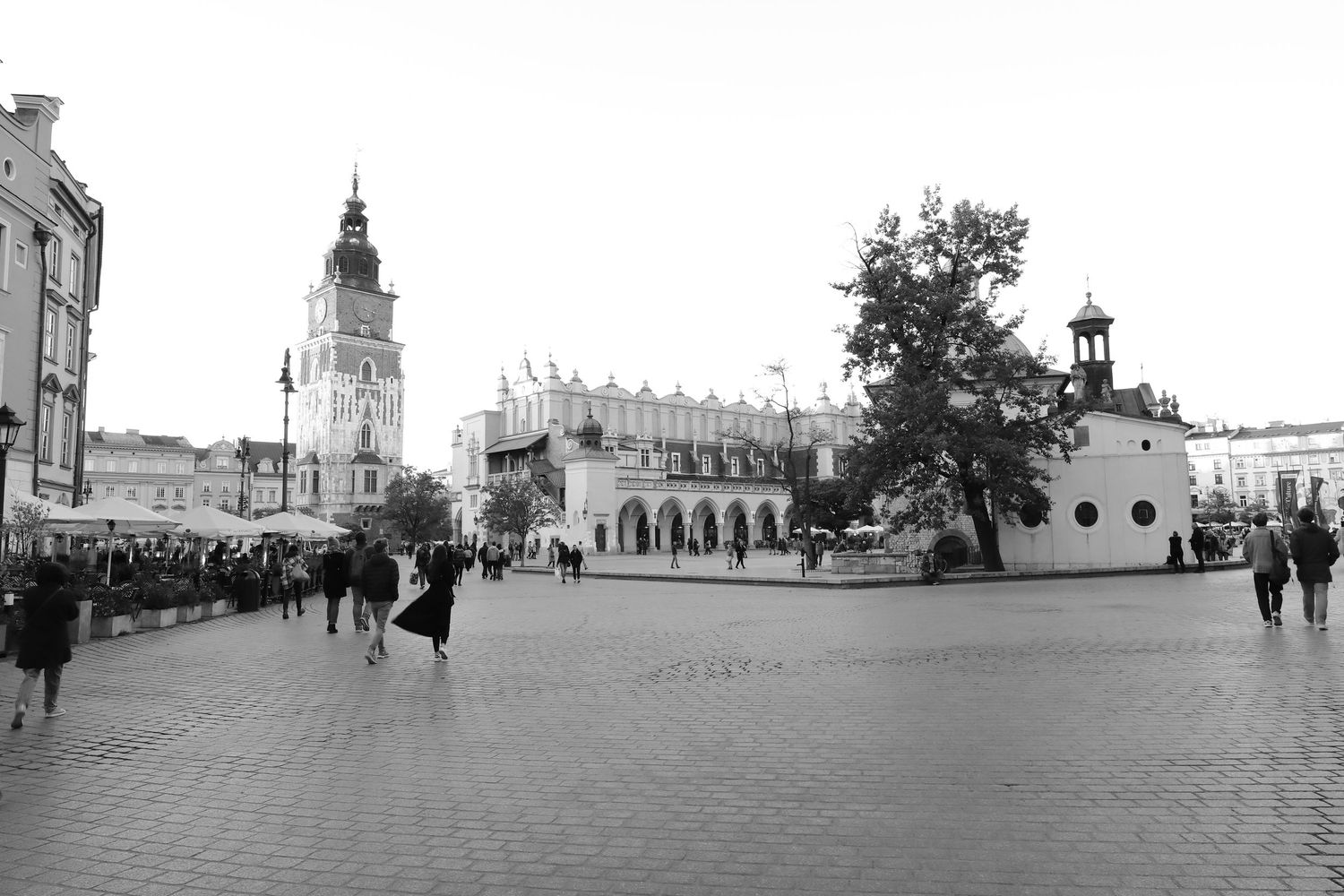 Historic market square with Gothic architecture and cobblestone plaza in black and white.