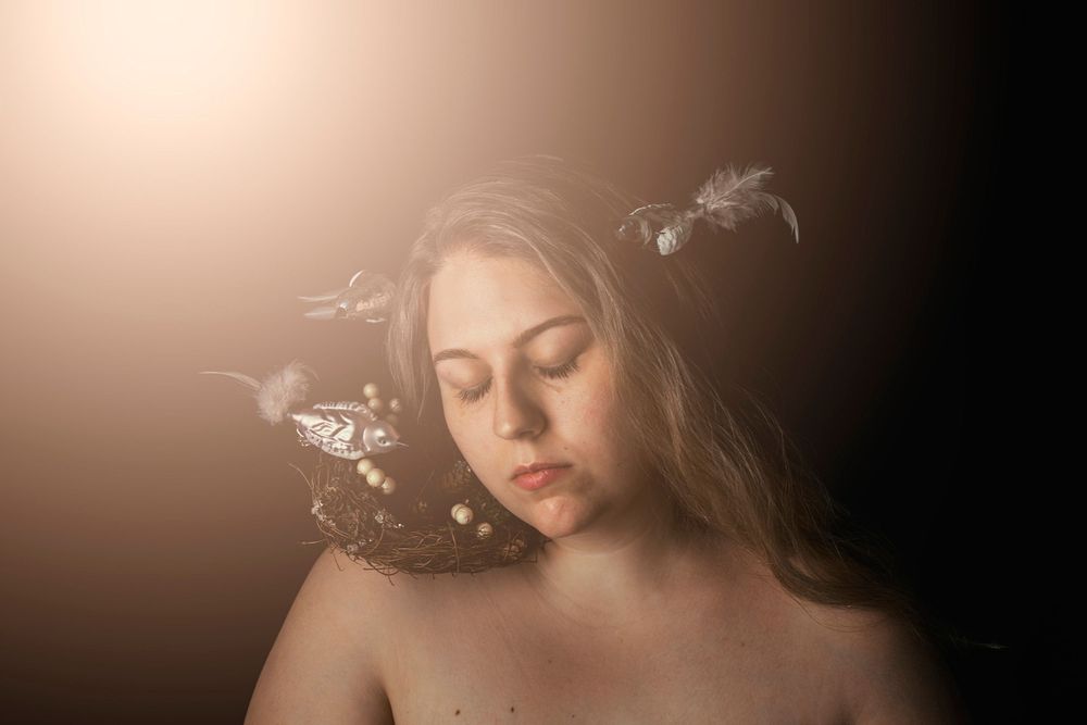 Atmospheric portrait with closed eyes and delicate flowers in sepia tones.
