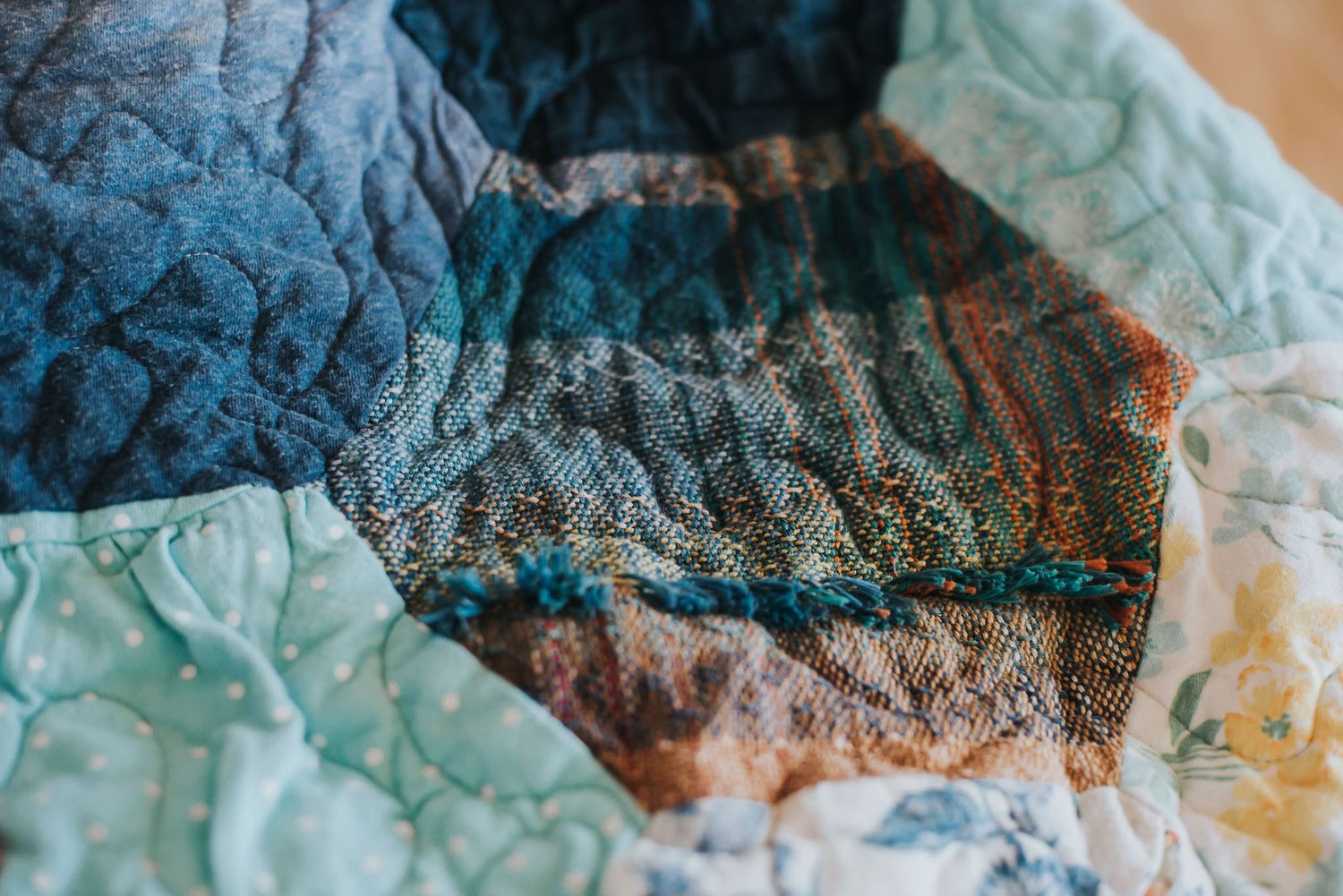 Textured hexagon memory quilt showcasing a piece of woven baby wrap that was used to carry the child the quilt is for.