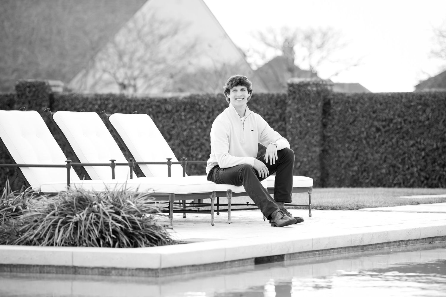 Black and white photo of poolside lounge chairs at an upscale venue.