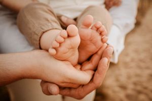Close-up of tiny baby feet being held in gentle hands.