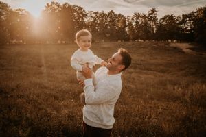 Intimate outdoor family photoshoot with warm sunset lighting and natural scenery.