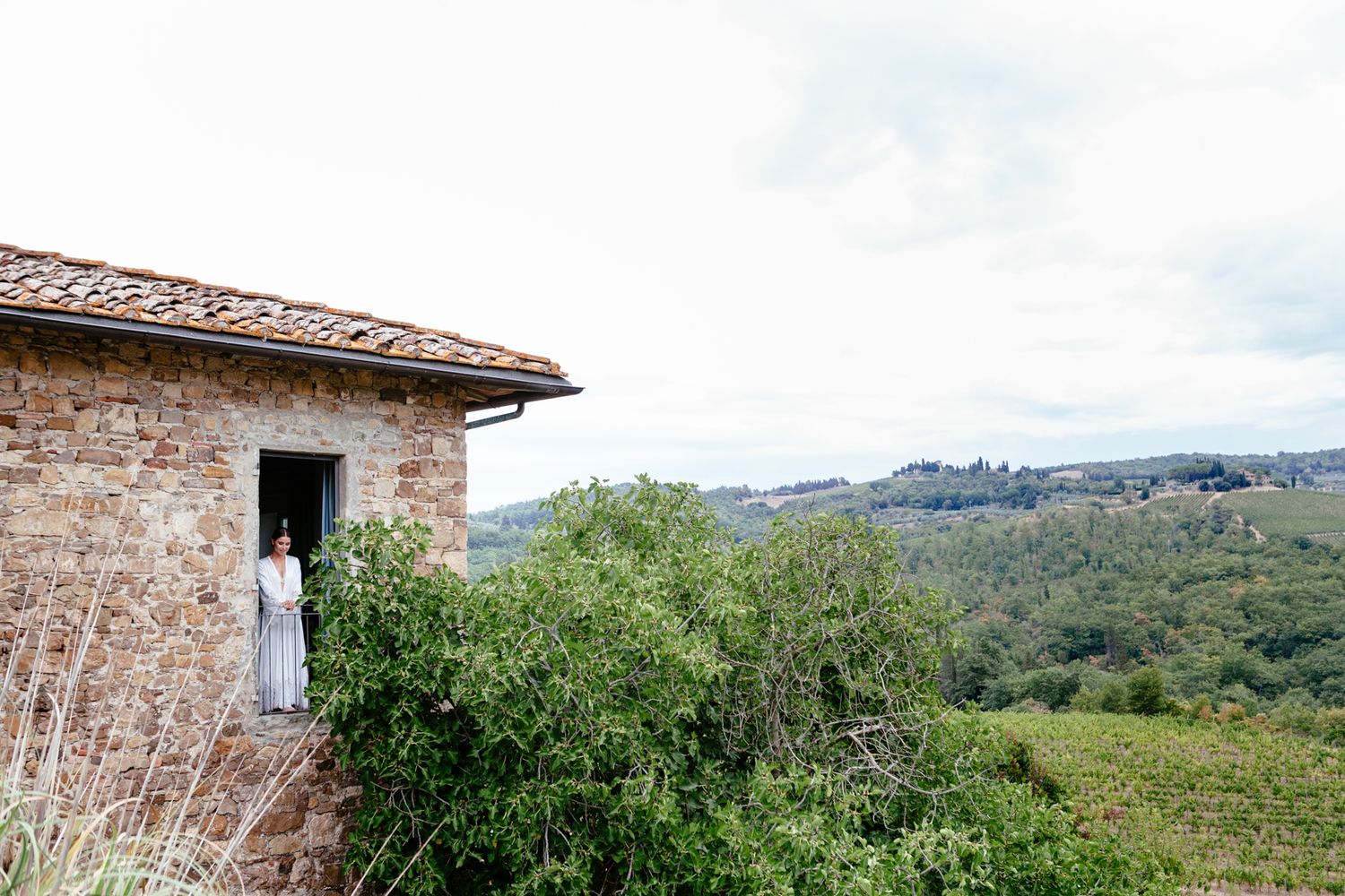 bride looks out at the Tuscan countryside