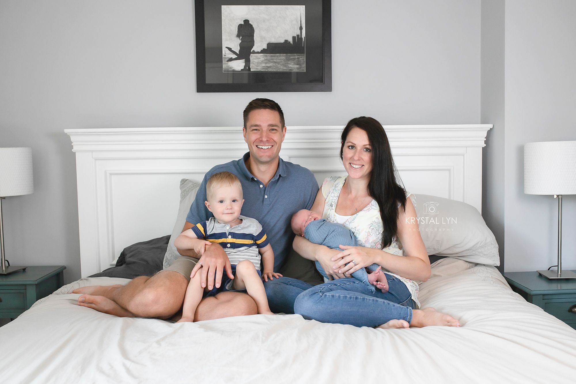 Lovely family posed at home on their bed while photographer captures memories
