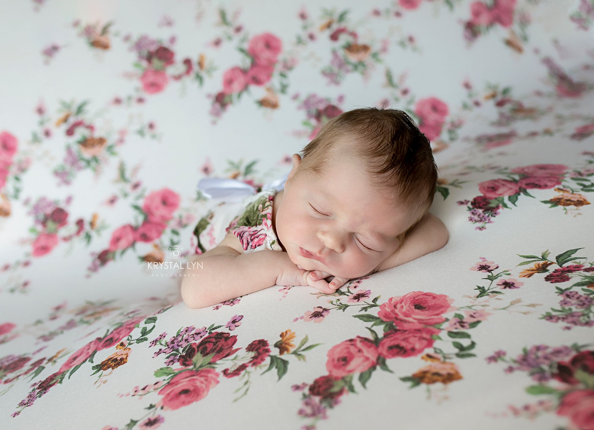 Posing baby on a beautiful floral fabric