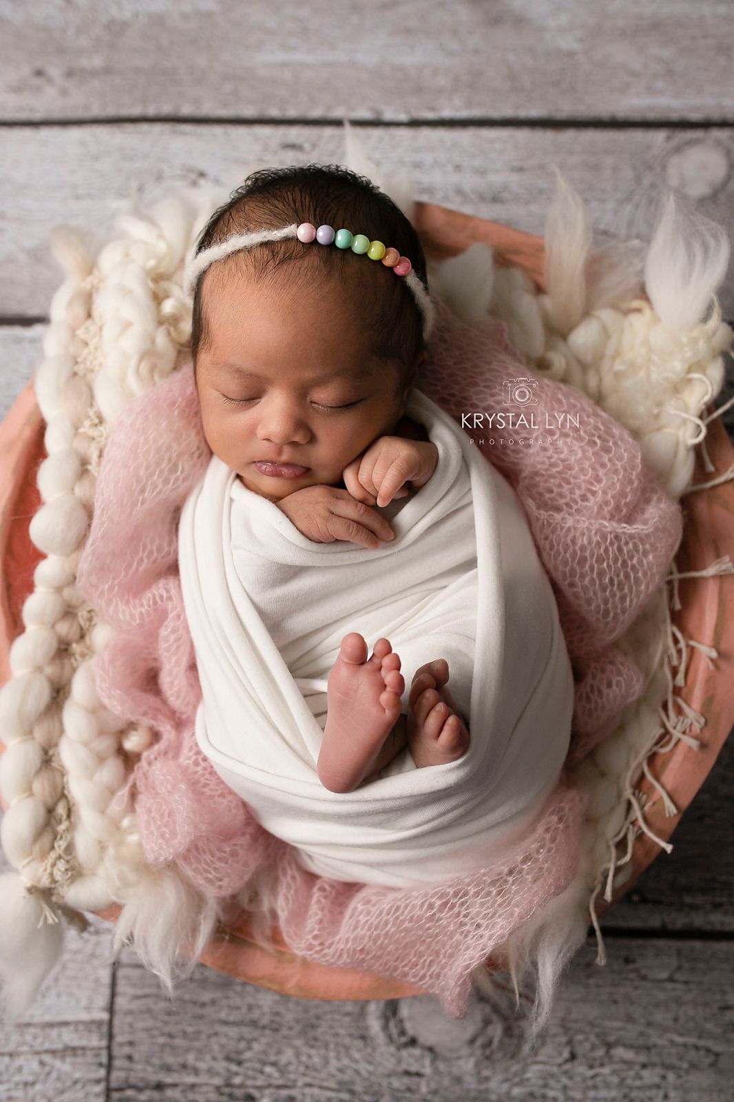 Rainbow baby all snug as a bug in a big pink bowl