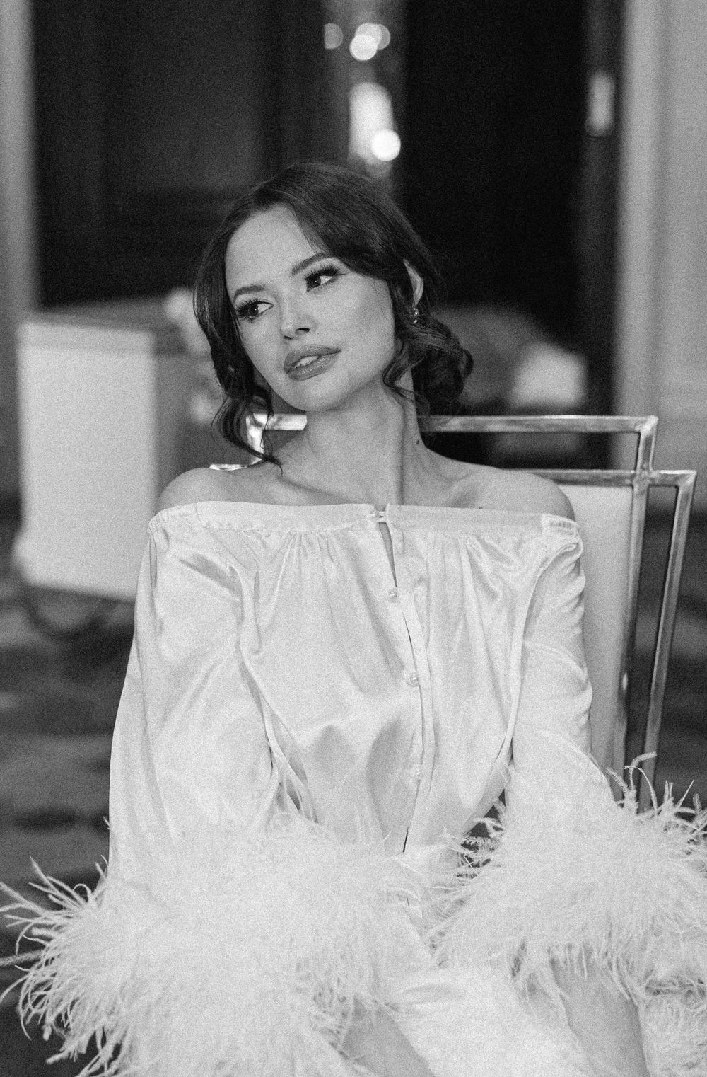 Classic black and white portrait featuring an off-shoulder feathered dress.