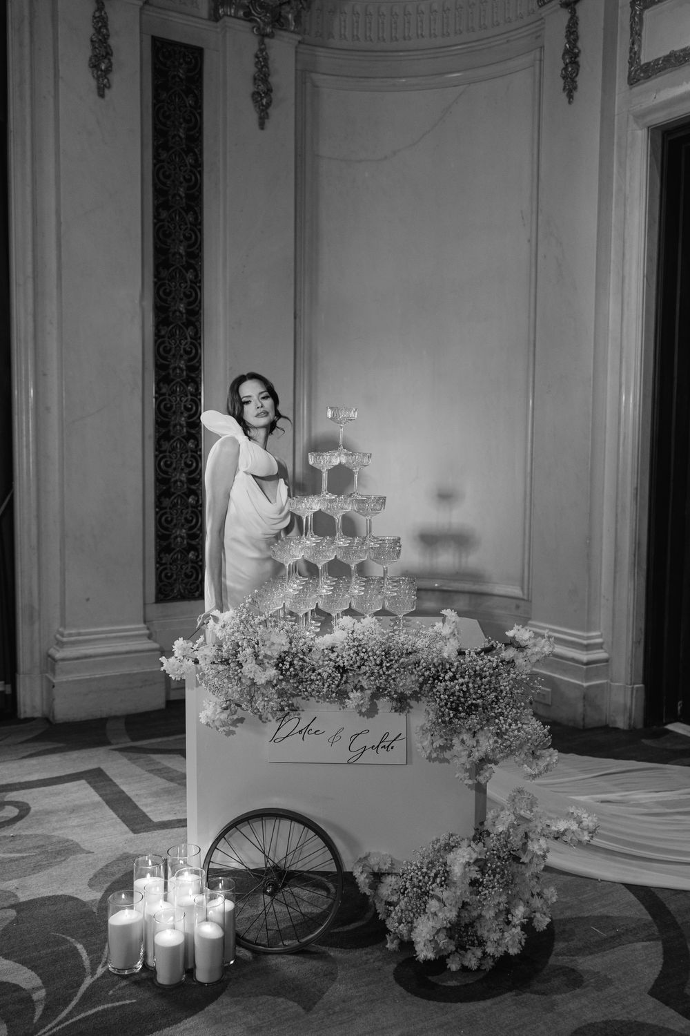 Elegant champagne tower with floral decorations and candles at an upscale event.