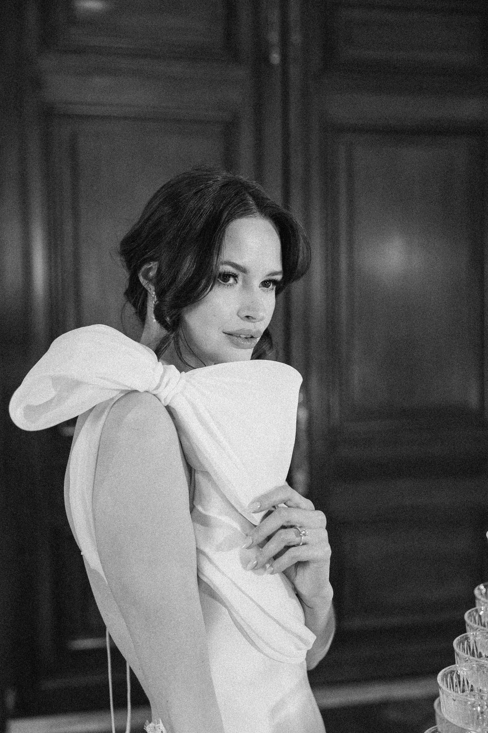 Elegant black and white portrait of bride in stylish dress with dramatic bow.