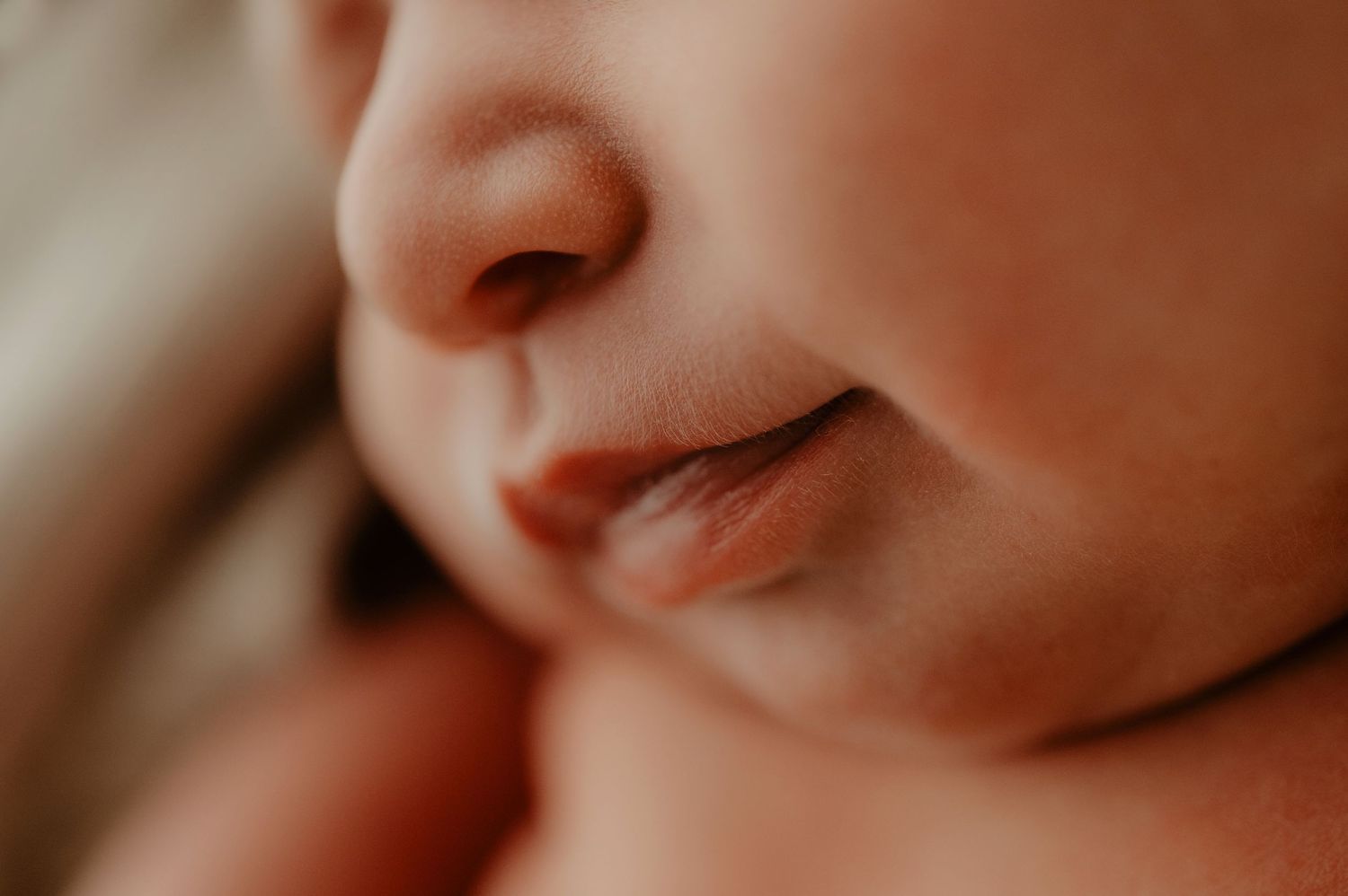 Gentle baby smile captured in warm natural light.