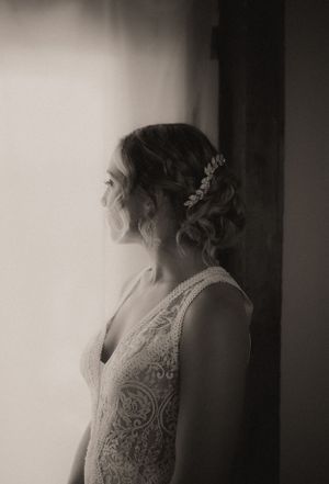 Artistic black and white portrait showcasing intricate lace wedding gown details.