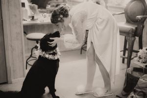 Black and white photo of a wedding party getting ready in an indoor setting.