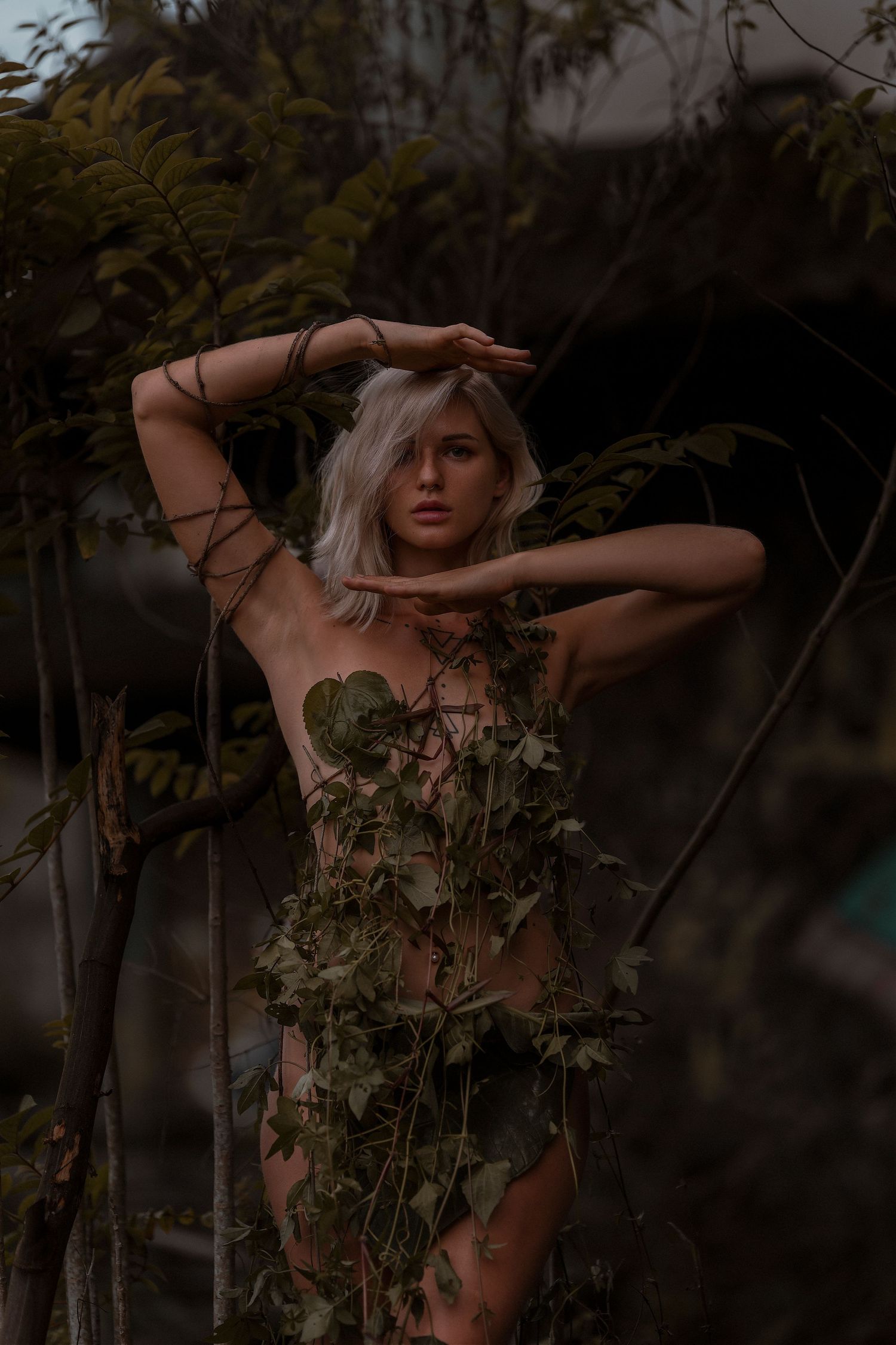Artistic nature portrait with ivy vines and moody forest lighting.