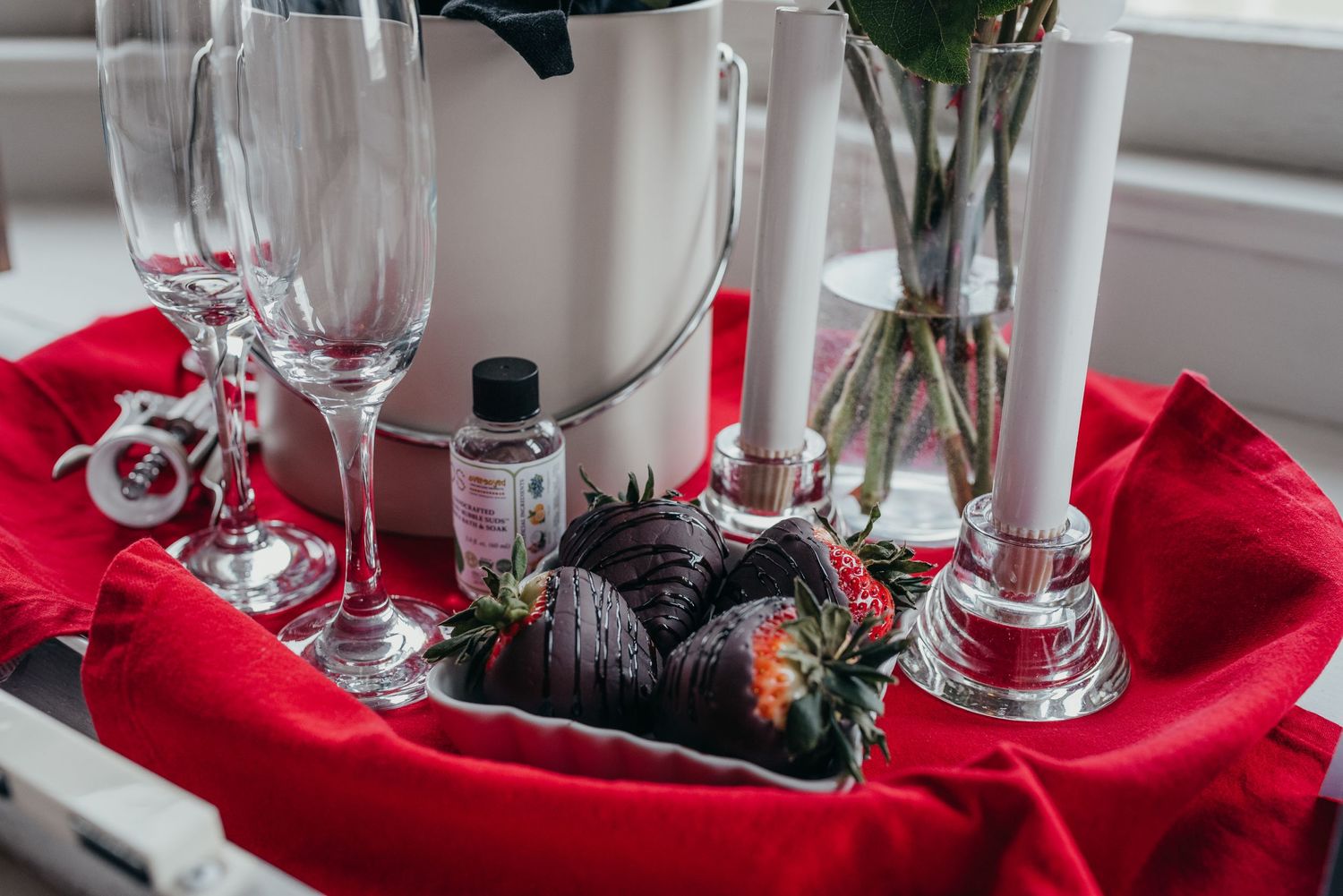 Wedding table setting with crystal glasses and red napkins arranged elegantly.