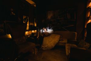 Dark moody indoor photography with dramatic side lighting in a vintage setting.