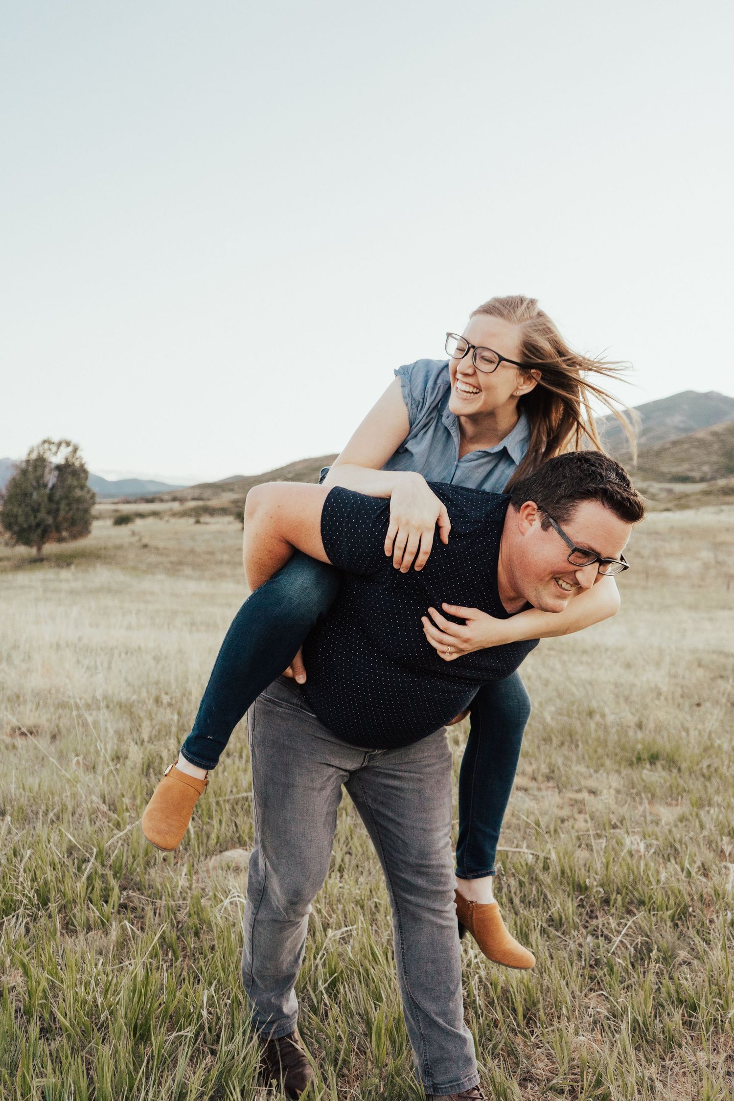 Utah couples photography piggyback ride in a field