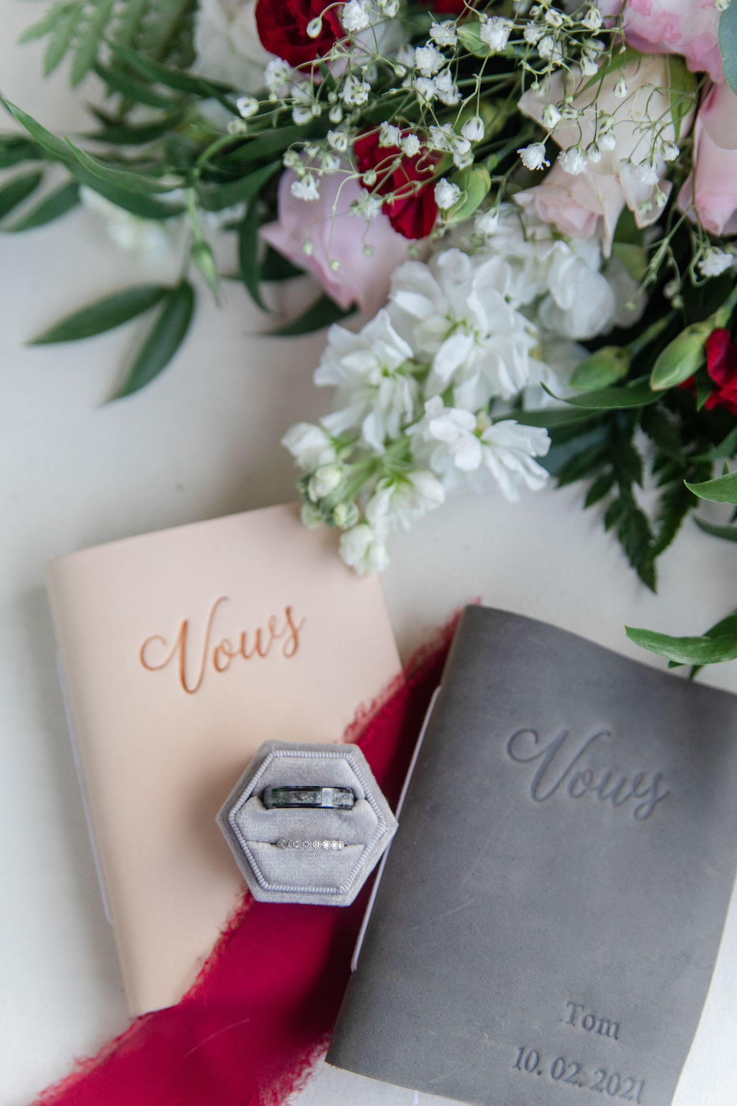 Wedding vow books with floral arrangements and personalized details.